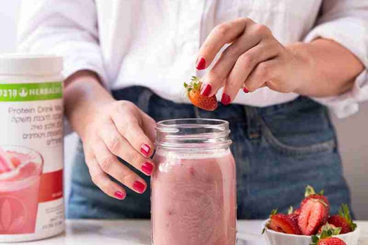קופסת שייק הרבלייף ברקע שייק מוכן עם תות שדה